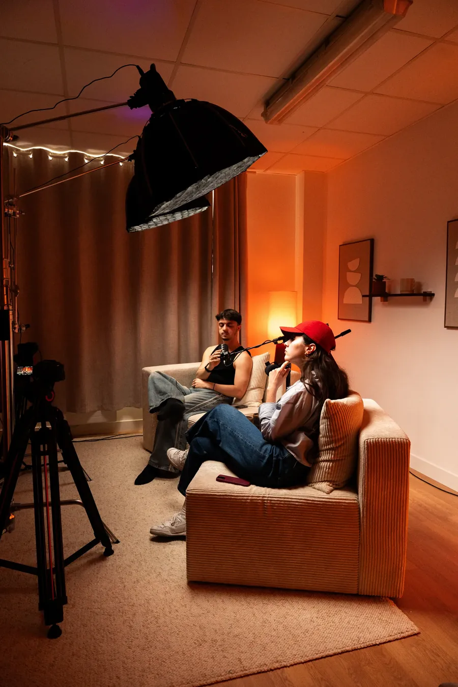 Tournage d'un podcast à deux voix, caméra et lumières au premier plan